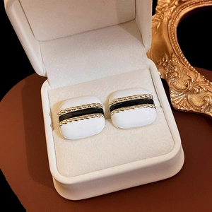 Detail of square vintage enamel earrings with pearl accents and gold rope borders