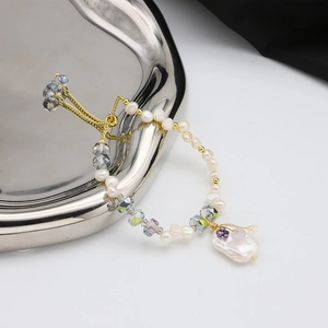 Baroque natural freshwater pearl bracelet with crystals and gold beads on white surface