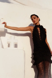 Detail of elegant black lace evening gown with ruffled layers and a halter neckline