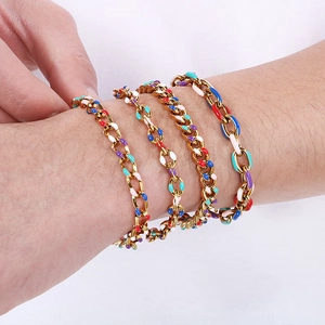 Dettaglio di modella con bracciali a catena cubana con smalto colorato in finitura oro