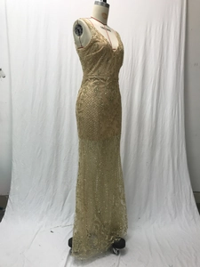 Detail of V-neck sleeveless gold sequin embroidery on mesh champagne evening gown