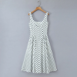 Détail d'une robe blanche à pois sans manches avec col en V et taille plissée