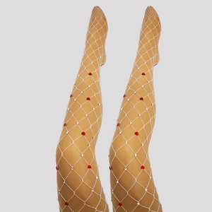 Detail shot of white fishnet stockings with red hearts and sparkling rhinestones