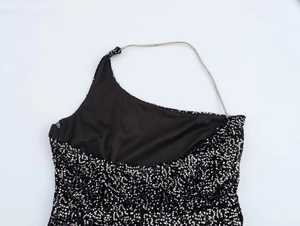 Detail of black sequin dress with silver halter chain and intricate metallic embroidery