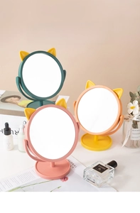 Detail of cute cat ear makeup mirrors in pastel pink and green for desk vanity decor