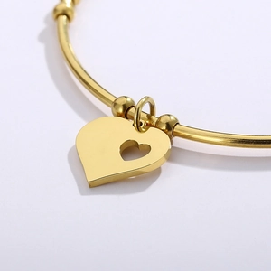 Minimalist gold heart charm bracelet with hollow design and polished metallic finish