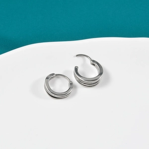 Close-up of vintage oxidized silver triple-layered hoop earrings with punk mechanical clasp