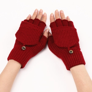 Detail of red knitted convertible mittens with button fastening and fashion label