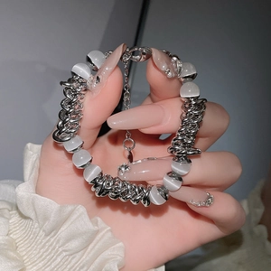 Detail eines silbernen Kettenarmbands mit Katzenaugenperlen und Karabinerverschluss