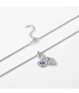 Macro shot of silver Hamsa Hand and blue Evil Eye pendants with sparkling zircons