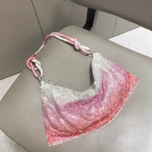 Close-up of pink to silver gradient rhinestones on underarm bag with woven strap