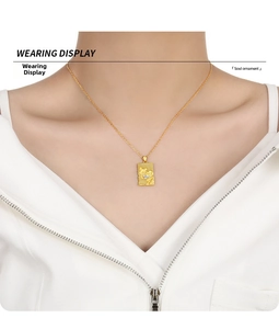 Macro detail of square gold pendant with embossed texture and small diamond inlay