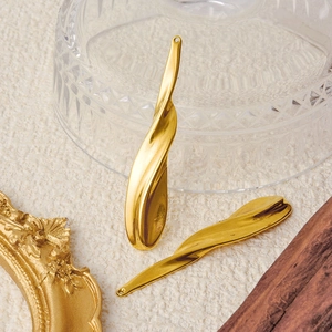 Minimalist wavy irregular 304 stainless steel pendants in gold finish on beige fabric