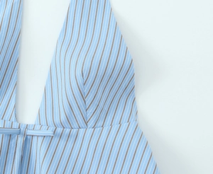 Detail of blue and white striped halter neck top with a delicate bow tied at the waist