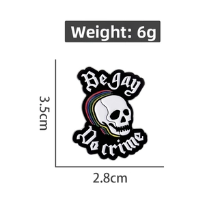 Detail of skull enamel pin with rainbow colors and Be Gay Do Crime text, size 3.5x2.8cm