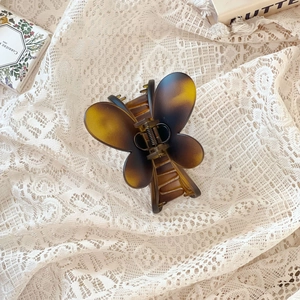 Gros plan d'une pince à cheveux papillon écaillée sur un fond en dentelle blanche