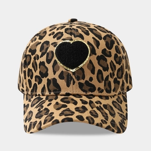 Close-up of leopard print baseball cap featuring a black heart patch with gold glitter edge