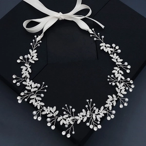 Detail of silver bridal headband with intricate crystal leaves and white faux pearls