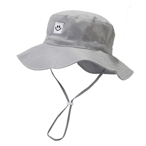 Detail of grey quick-dry sun hat for kids featuring smiley patch and adjustable chin strap