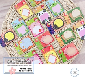 Close-up of cute cartoon animal sticky notes in panda and frog shapes on woven mat