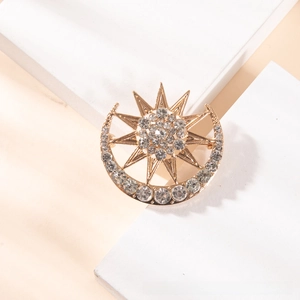Detail of a golden crescent moon and star brooch set with sparkling crystal rhinestones
