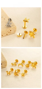 Macro display of heart, star, and moon titanium piercing studs on a textured stone surface