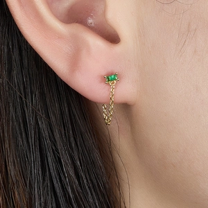 Detail of s925 silver gold plated earring with emerald cut green zircon and gold chain