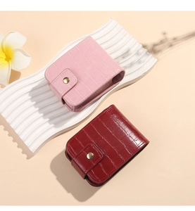 Detail of pink and dark red faux crocodile leather cases with golden snap buttons