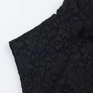 Detailed macro view of black floral lace fabric with intricate cutout patterns