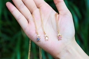 Close-up of golden necklace featuring micro-set zircon boy and girl character pendants