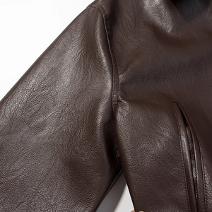 Detail of underarm seam and side pocket on a dark brown loose leather jacket