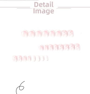 Close-up of white French tip press-on nails with small heart patterns and soft pink base