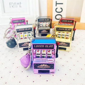 Mini Lucky Slot Machine keychains in various metallic colors on a lace background