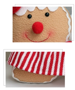 Close-up of fabric gingerbread man with red pom-pom nose and white wavy stitching details