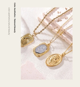 Detailed view of vintage gold layered necklace set with moon, rose, and angel pendants