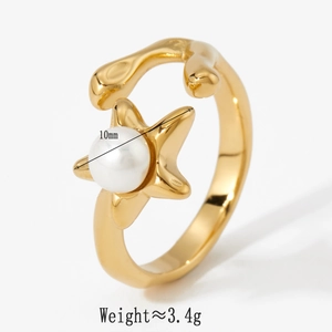 Detail of gold star and pearl open ring showing 10mm star charm and polished finish