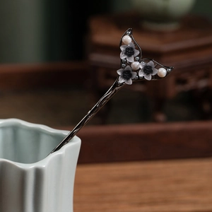 Detailed view of alloy hair stick with dark leaves, gradient flowers and white pearls