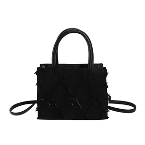 Minimalist black quilted crossbody bag with textured fabric finish and leather handle