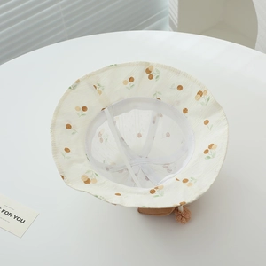 Detail showing breathable mesh lining and secure chin strap on baby cherry print sun hat