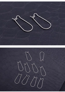 Detailed view of silver stainless steel earring hooks on black leather background
