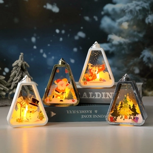 Three triangular Christmas LED lanterns with snowman and Santa scenes on vintage books