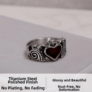 Macro shot of titanium steel ring featuring a red heart and intricate scroll engraving
