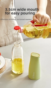Close-up of 3.5cm wide-mouth glass oil dispenser bottle with easy-fill design and green cap