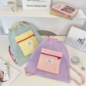 Détail de sacs à dos en maille avec cordon en vert menthe et lilas et poches contrastées