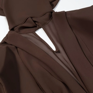 Détail du décolleté en V profond et de la capuche sur une robe en mousseline marron