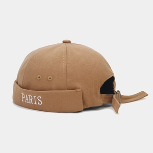 Close-up of khaki docker hat with white PARIS embroidery and adjustable metal buckle strap