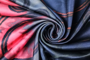 Detail of silk-like fabric with vibrant red, navy, and black wave patterns and high sheen