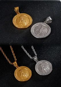 Detail showing gold and silver Virgin Mary pendants with engraved prayer around the edge