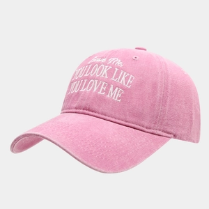 Détail de la broderie blanche sur une casquette de baseball rose en coton délavé