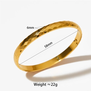 Detail of 6mm wide gold geometric bangle with 58mm diameter and rhombus texture